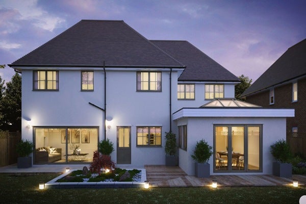 home extension lit up at night with bifold doors and roof lantern.